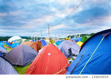 Camping, tents and outdoor music festival in park on holiday or vacation in summer. Camp, site and shelter setup at party, event or travel in countryside for concert, adventure and crowded carnival Camping, tents and outdoor music festival in park on holiday or vacation in summer. Camp, site and shelter setup at party, event or travel in countryside for concert, adventure and crowded carnival 139834010