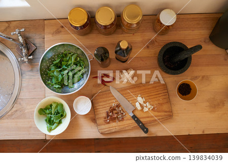 Cooking, green and salad in home with diet, nutrition and healthy food with dinner from above. Kitchen, vegetable and leaves for organic and vegan lunch with bowl and wood board in house for wellness Cooking, green and salad in home with diet, nutrition and healthy food with dinner from above. Kitchen, vegetable and leaves for organic and vegan lunch with bowl and wood board in house for wellness 139834039