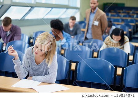 Exam, classroom and student with pen for thinking, assessment and writing at campus. Woman, planning and sitting with paper for brainstorming, education and growth of knowledge in university class Exam, classroom and student with pen for thinking, assessment and writing at campus. Woman, planning and sitting with paper for brainstorming, education and growth of knowledge in university class 139834071