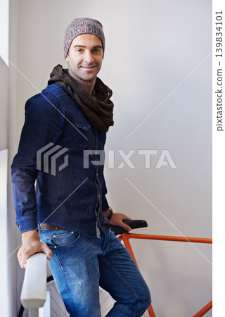Portrait, fashion and bike with man in hallway of home for travel, transport or commute. Apartment, sustainability and zero emission bicycle with confident young person on stairwell in winter style Portrait, fashion and bike with man in hallway of home for travel, transport or commute. Apartment, sustainability and zero emission bicycle with confident young person on stairwell in winter style 139834101