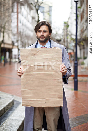 Sad, business and man with poster, unemployed in city and professional with stress and anxiety. Person, outdoor and financial criss with worker and stock market crash with job loss with recession Sad, business and man with poster, unemployed in city and professional with stress and anxiety. Person, outdoor and financial criss with worker and stock market crash with job loss with recession 139834173