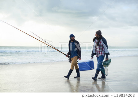 Hobby, fishing and men walking on beach together with cooler, tackle box and holiday conversation. Ocean, fisherman and friends with rods, bait and tools at waves on winter morning vacation at sea. Hobby, fishing and men walking on beach together with cooler, tackle box and holiday conversation. Ocean, fisherman and friends with rods, bait and tools at waves on winter morning vacation at sea. 139834208