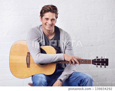 Man, guitar and musician with portrait for music, acoustic for entertainment and performance on wall background. Busker, artist and musical instrument for art or creativity, track or song with talent Man, guitar and musician with portrait for music, acoustic for entertainment and performance on wall background. Busker, artist and musical instrument for art or creativity, track or song with talent 139834292