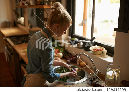 Woman in kitchen, cleaning vegetables and cooking, hygiene and health for food and nutrition at home. Chef skill, washing produce and catering, vegan or vegetarian meal prep with preparation 139834399
