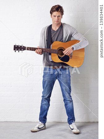 Man, guitar and artist in portrait with creativity and music, acoustic for entertainment and performance on wall background. Busker, musician and musical instrument for art, track or song with talent Man, guitar and artist in portrait with creativity and music, acoustic for entertainment and performance on wall background. Busker, musician and musical instrument for art, track or song with talent 139834401
