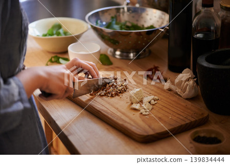 Cooking, hands and salad chop in a home with diet, nutrition and healthy food with person. Kitchen, knife and leaves for organic and vegan lunch with bowl and wood board in a house with wellness Cooking, hands and salad chop in a home with diet, nutrition and healthy food with person. Kitchen, knife and leaves for organic and vegan lunch with bowl and wood board in a house with wellness 139834444