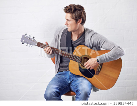 Man, guitar and musician with art and music, acoustic for entertainment and performance against wall background. Busker, artist and musical instrument for creativity, track or song with talent Man, guitar and musician with art and music, acoustic for entertainment and performance against wall background. Busker, artist and musical instrument for creativity, track or song with talent 139834445