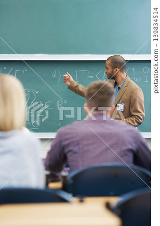 Board, lecture and professor with students in classroom for mathematics lesson at university campus. Education, learning and college teacher explaining work or teaching for assignment, test or exam. Board, lecture and professor with students in classroom for mathematics lesson at university campus. Education, learning and college teacher explaining work or teaching for assignment, test or exam. 139834514