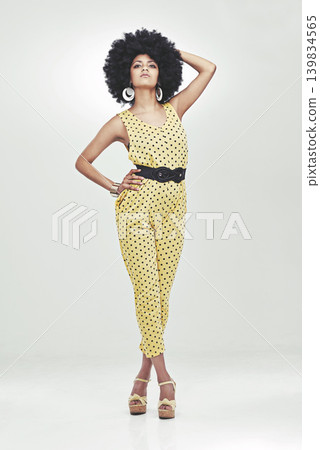 Black woman, fashion and retro with portrait in studio for vintage, unique look and face with afro. African girl, stylish and person with curly hair, jumpsuit and confident with white background Black woman, fashion and retro with portrait in studio for vintage, unique look and face with afro. African girl, stylish and person with curly hair, jumpsuit and confident with white background 139834565