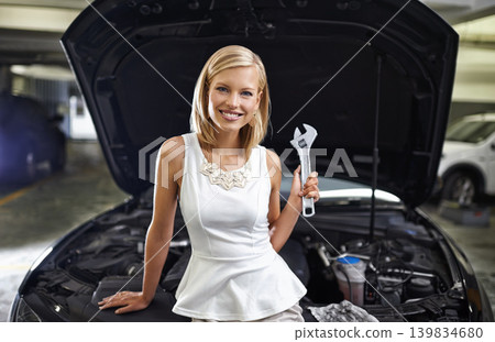 Woman, portrait and spanner at car engine for repair in parking garage or electrical failure, leak or mechanical. Female person, fashion and smile with tool at vehicle bonnet for problem, oil or auto Woman, portrait and spanner at car engine for repair in parking garage or electrical failure, leak or mechanical. Female person, fashion and smile with tool at vehicle bonnet for problem, oil or auto 139834680
