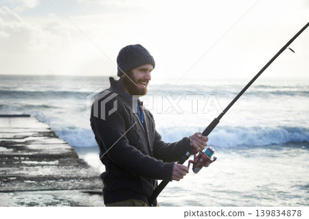 Fishing, smile and travel with man at beach for adventure, holiday and hobby break. Sunset, calm and patience with male fisherman and casting rod pole in nature for recreation, view and vacation Fishing, smile and travel with man at beach for adventure, holiday and hobby break. Sunset, calm and patience with male fisherman and casting rod pole in nature for recreation, view and vacation 139834878