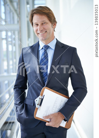 Clipboard, office and portrait of business man in corridor with documents, paperwork and contract. Professional, corporate lawyer and person with papers for planning, notes and project management Clipboard, office and portrait of business man in corridor with documents, paperwork and contract. Professional, corporate lawyer and person with papers for planning, notes and project management 139835013