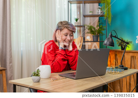 Woman opening laptop receiving lottery winning message, celebrating joyful excited happy reaction Woman opening laptop receiving lottery winning message, celebrating joyful excited happy reaction 139835015
