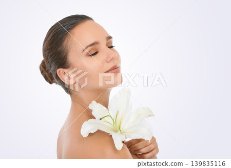 Cosmetics, flower and beautiful woman in studio with glamour, glow and makeup face routine. Beauty, confident and young female person with floral plant for facial cosmetology by white background. 139835116