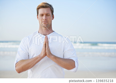 Man, meditation on beach and prayer for zen, wellness and holistic healing outdoor for calm and yoga. Ocean, fresh air and travel with mindfulness for peace of mind, wellbeing and spiritual in nature 139835218