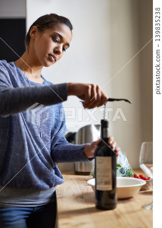 Woman, open wine and bottle for dinner, evening meal with corkscrew and preparing to drink for enjoyment and nutrition. Alcoholic beverage, tools or equipment with cooking for dining in kitchen Woman, open wine and bottle for dinner, evening meal with corkscrew and preparing to drink for enjoyment and nutrition. Alcoholic beverage, tools or equipment with cooking for dining in kitchen 139835238