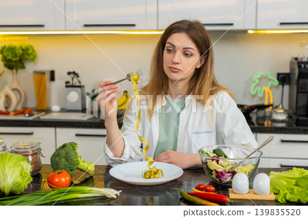 Middle-aged woman upset with measuring tape in kitchen thinking about weight loss diet willpower fit Middle-aged woman upset with measuring tape in kitchen thinking about weight loss diet willpower fit 139835520