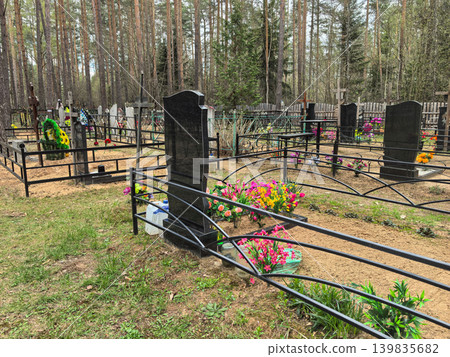 Quiet remembrance in a serene forest cemetery with colorful flowers Quiet remembrance in a serene forest cemetery with colorful flowers 139835682