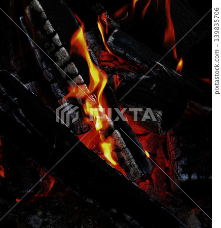 The blazing heat under black wood covered with white flakes of ash 139835706