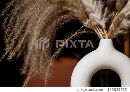 Boho style decor with dried pampas grass in a modern ceramic vase. Warm tones, soft textures and minimal composition create a trendy natural aesthetic for interior, branding and lifestyle visuals. Boho style decor with dried pampas grass in a modern ceramic vase. Warm tones, soft textures and minimal composition create a trendy natural aesthetic for interior, branding and lifestyle visuals. 139835785