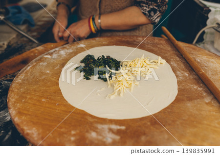 Traditional Turkish flatbread preparation with spinach and cheese filling Traditional Turkish flatbread preparation with spinach and cheese filling 139835991