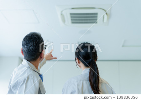 Workers inspecting air conditioners 139836356