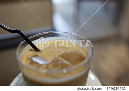 Iced café au lait. A cold drink with a black straw. A classic summer drink with ice. Iced café au lait. A cold drink with a black straw. A classic summer drink with ice. 139836362