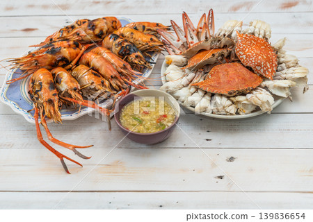 Grilled river prawns steamed crab spicy seafood sauce served on white table fresh seafood meal rich in protein coastal cuisine Grilled river prawns steamed crab spicy seafood sauce served on white table fresh seafood meal rich in protein coastal cuisine 139836654