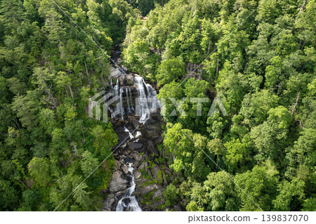 Whitewater Falls in Nantahala National Forest, North Carolina, USA. Beautiful landscape of high waterfall with falling down clear water from rocky boulders between green lush woods Whitewater Falls in Nantahala National Forest, North Carolina, USA. Beautiful landscape of high waterfall with falling down clear water from rocky boulders between green lush woods 139837070