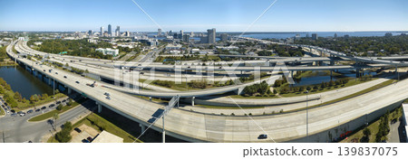 Aerial view of Jacksonville city with high office buildings and american freeway intersection with fast driving cars and trucks. View from above of USA transportation infrastructure 139837075