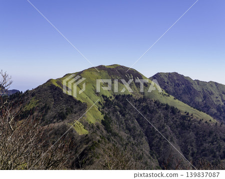 The gentle slopes of Sasagamine, covered in bamboo grass, and the mountain range of Shikoku stand out against the blue sky of early summer. The gentle slopes of Sasagamine, covered in bamboo grass, and the mountain range of Shikoku stand out against the blue sky of early summer. 139837087