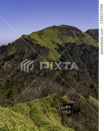 The gentle slopes of Sasagamine, covered in bamboo grass, and the mountain range of Shikoku stand out against the blue sky of early summer. The gentle slopes of Sasagamine, covered in bamboo grass, and the mountain range of Shikoku stand out against the blue sky of early summer. 139837094