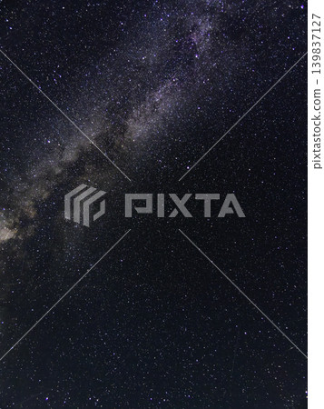 The Milky Way stretches across a sky full of stars. The silhouette of the mountains and the beautiful night sky of the galaxy. 139837127