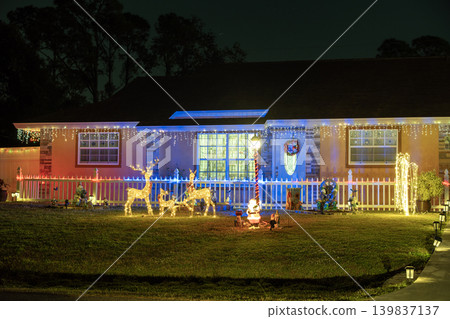 Festive yard display with glowing lights and Christmas decorations at a Florida family home. New Year holiday joy. 139837137
