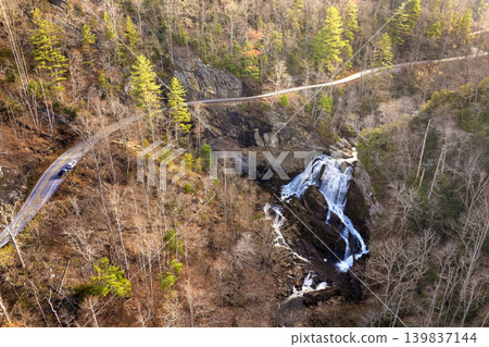 Scenic drive near Cullasaja Falls in the Nantahala National Forest. Highlands Road curves through rocky terrain and fall woods. Scenic drive near Cullasaja Falls in the Nantahala National Forest. Highlands Road curves through rocky terrain and fall woods. 139837144