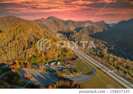 Rest area between golden fall forest near busy multilane American freeway with fast moving cars and trucks. Recreational resting place during interstate traveling thru USA mountains Rest area between golden fall forest near busy multilane American freeway with fast moving cars and trucks. Recreational resting place during interstate traveling thru USA mountains 139837145