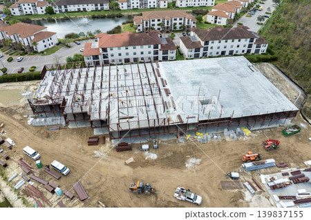 Construction site with hardhat workers assembling metal frame walls. Aerial view of large development area of commercial structure. Real estate market in the USA 139837155