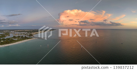 Aerial view of sea shore near Venice, Florida with white yachts at sunset floating on sea waves. North and South Jetty on Nokomis beach. Motor boat recreation on ocean surface Aerial view of sea shore near Venice, Florida with white yachts at sunset floating on sea waves. North and South Jetty on Nokomis beach. Motor boat recreation on ocean surface 139837212