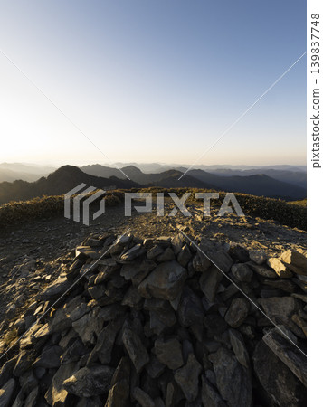 View of the Ishizuchi mountain range at dawn: bamboo grass ridges and the morning glow View of the Ishizuchi mountain range at dawn: bamboo grass ridges and the morning glow 139837748