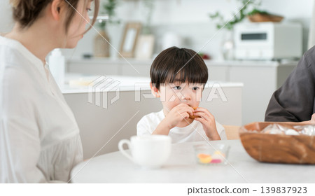 A boy enthusiastically eats sweets and his favorite donuts as a snack. 139837923