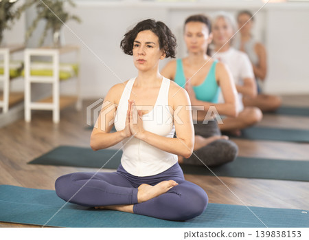 Adult woman doing yoga in group in studio 139838153