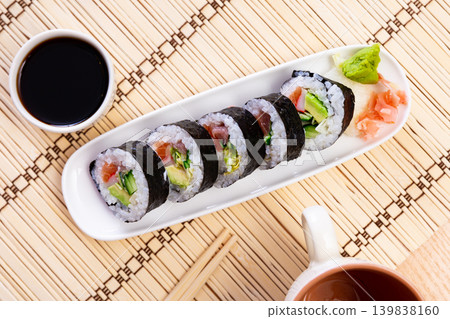 Sushi roll futomaki with cucumber, avocado, tuna, surimi, salad and salmon Sushi roll futomaki with cucumber, avocado, tuna, surimi, salad and salmon 139838160