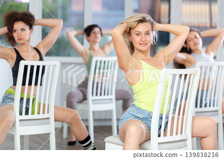 Sitting on chair, girl with long hair train to perform lap dance, interacting with imaginary partner Sitting on chair, girl with long hair train to perform lap dance, interacting with imaginary partner 139838216