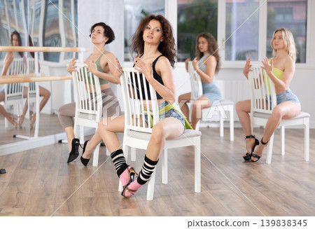 Brunette in heels leading group exotic chair dance class Brunette in heels leading group exotic chair dance class 139838345