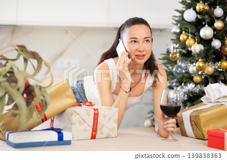 woman is relaxing at home with glass of wine during New Year holidays woman is relaxing at home with glass of wine during New Year holidays 139838363