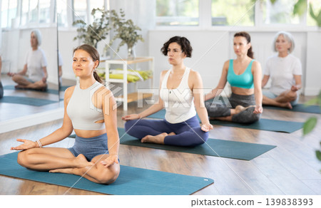 Girl meditating in lotus pose during group yoga practice Girl meditating in lotus pose during group yoga practice 139838393