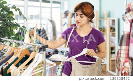 Young girl shopping for summer outfits in store Young girl shopping for summer outfits in store 139838492