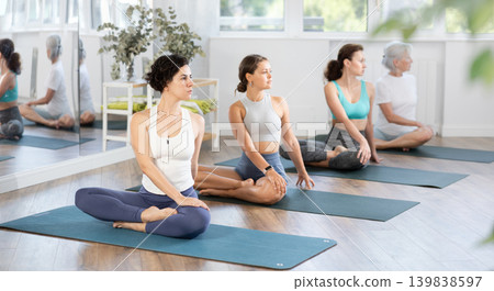 Adult woman doing yoga in group in studio Adult woman doing yoga in group in studio 139838597