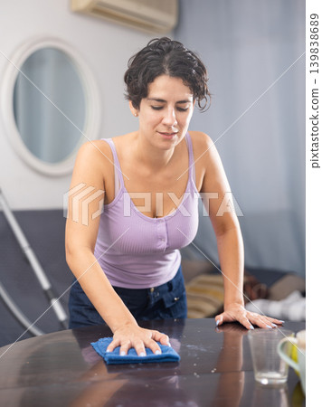 Woman with rag cleaning room at home 139838689
