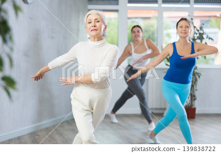 Cheerful senior woman training zumba with group 139838722
